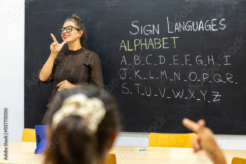 Sign language class with teacher and alphabet lesson on chalkboard photo