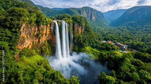 The majestic Agueraz Waterfall stands tall, cascading down lush green cliffs with a roaring intensity that mesmerizes all who lay eyes upon it.