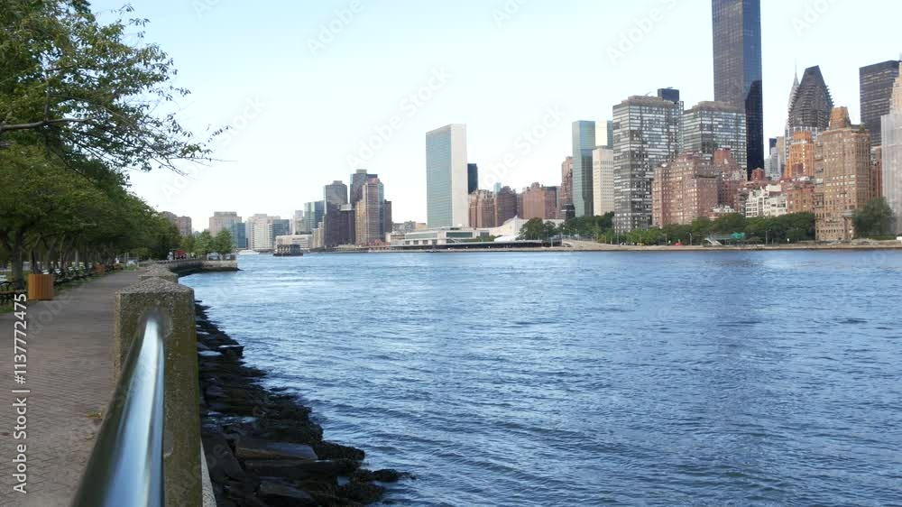New York City waterfront skyline, Manhattan Midtown buildings, riverfront skyscrapers by East river water. Waterside cityscape view from Roosevelt Island. United States architecture and real estate. New York City waterfront skyline, Manhattan Midtown buildings, riverfront skyscrapers by East river water. Waterside cityscape view from Roosevelt Island. United States architecture and real estate.