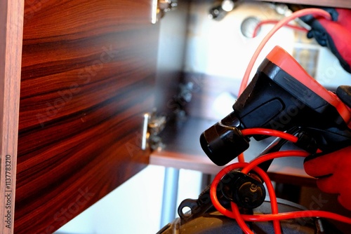 A plumber is trying to open a clogged bathroom pipe using a camera system. Close-up view of opening a clogged sewer drain with a robot. Handyman, repair and plumbing works.
 photo