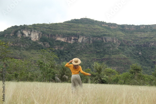 mulher de saia longa e chapéu correndo com serra de santo antonio ao fundo em campo maior, piauí  photo