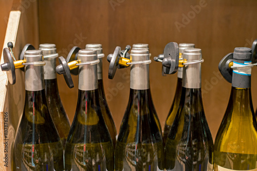 white sparkling wine or port in a transparent glass bottle in a display case in a supermarket. white wine tasting photo