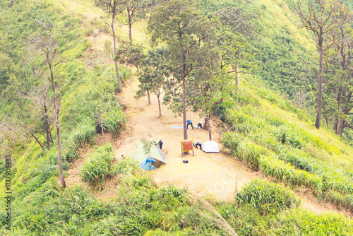 Landscape camping ground hill with thick white fog of Khao Chang Phueak Kanchanaburi Thailand at Thong Pha Phum National. Nature amazing mountain in tropical yellow, gold, green forest of park. photo