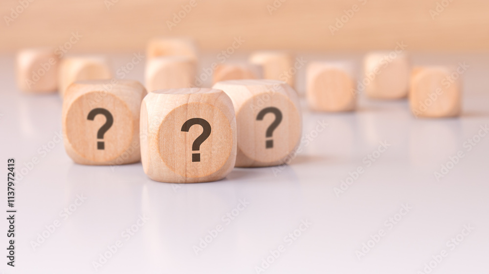 On the table sits a collection of mysterious wooden blocks adorned with question marks On the table sits a collection of mysterious wooden blocks adorned with question marks