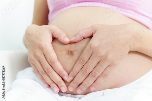 Wallpaper Mural Asian pregnant woman touches her stomach and makes her hands in heart shape. Torontodigital.ca