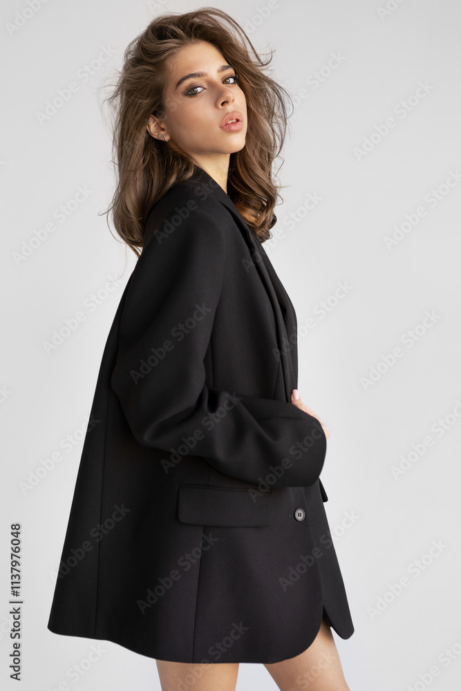 Beautiful young woman with brown hair In Black Blazer looks camera isolated on white background. Portrait Fashion model posing in studio, beauty, elegance and modern style Beautiful young woman with brown hair In Black Blazer looks camera isolated on white background. Portrait Fashion model posing in studio, beauty, elegance and modern style