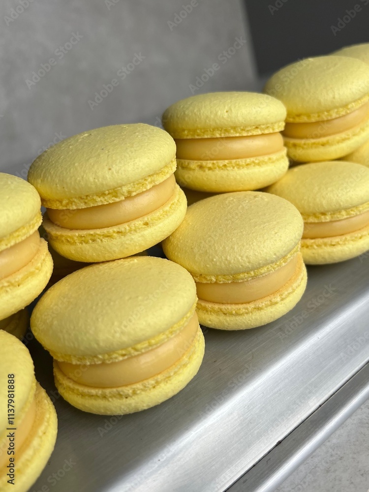 Bright Yellow Macarons with Lemon Cream Filling – Close-Up Perspective. Close-up shot of bright yellow macarons filled with creamy lemon-flavored ganache Bright Yellow Macarons with Lemon Cream Filling – Close-Up Perspective. Close-up shot of bright yellow macarons filled with creamy lemon-flavored ganache