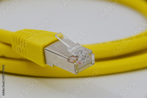 Den Helder, Netherlands. december 14, 2024. close up of a yellow ethernet cable on a white background.