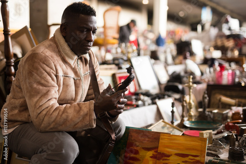  Man looks at second-hand items at a flea market photo