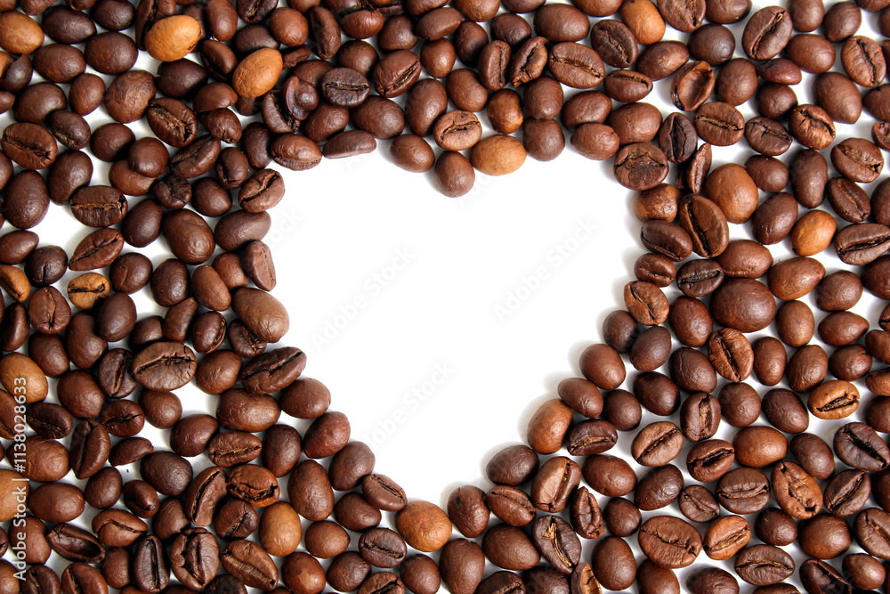 On a white background lies scattered coffee in the shape of a heart with space for text. On a white background lies scattered coffee in the shape of a heart with space for text.