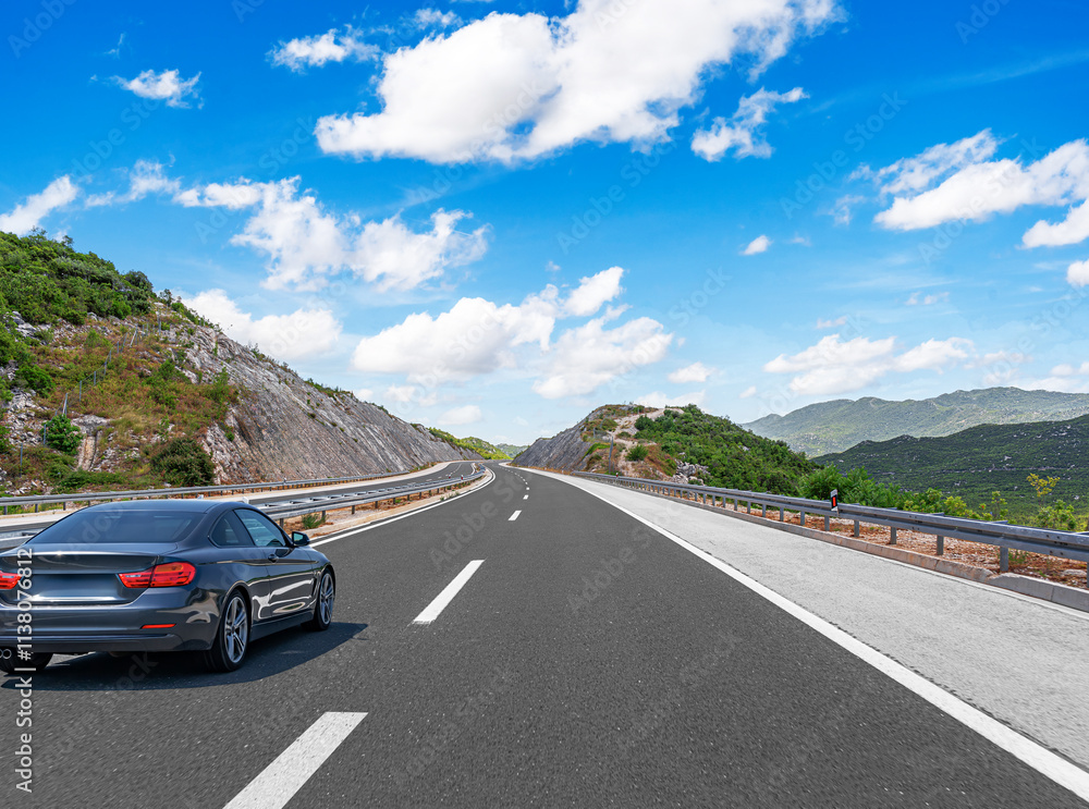 The car is driving along the highway surrounded by picturesque nature.