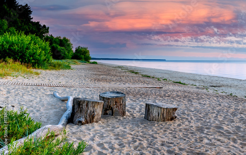 Coastal landscape with recreation area and resting wooden trunks, during colo...
