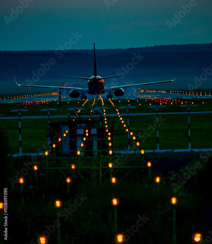 A commercial airplane is taking off from an airport runway during the night