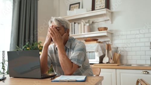 Stressed senior businessman holding head and thinking about solution while suffering from job problem or deceasing sales. Employee checking at computer while sitting at home. Remote working. Myrmidon. photo