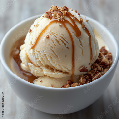 Creamy vanilla ice cream topped with caramel sauce and chopped nuts, served in white bowl. delicious dessert perfect for any occasion, evoking feelings of indulgence and satisfaction photo