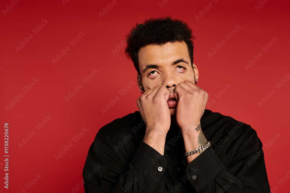 The young man shows a playful expression while playfully stretching his face. The young man shows a playful expression while playfully stretching his face.