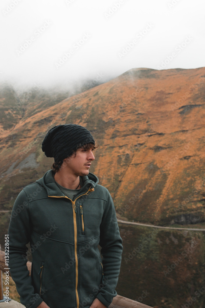 Naklejka premium Man in Mountain Landscape with Autumn Colors and Fog