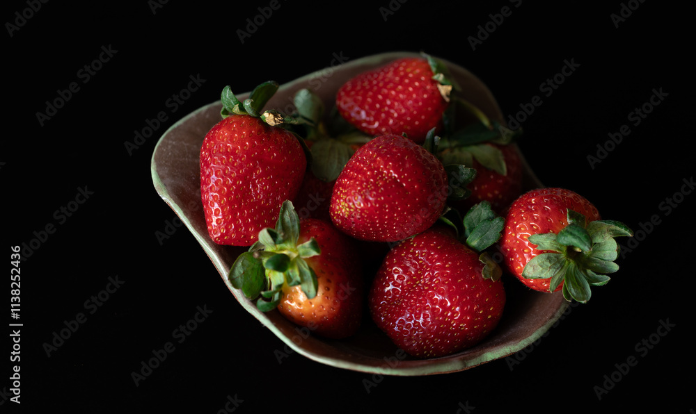 Strawberry on plate with black background Strawberry on plate with black background