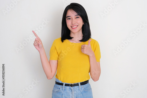 A woman smiling happy while pointing and give thumbs up to the right side photo