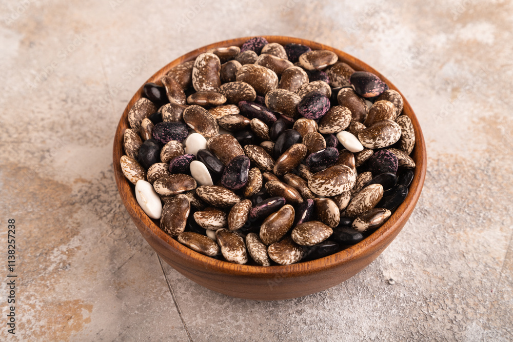 wooden bowl with Kidney beans on brown concrete, side view, close up wooden bowl with Kidney beans on brown concrete, side view, close up