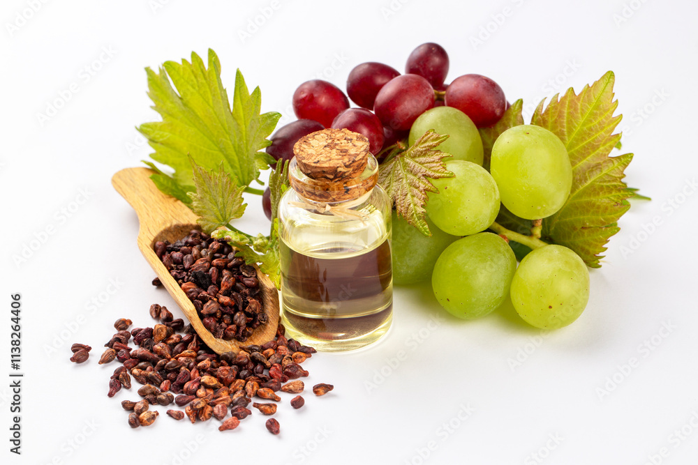 Grape seed oil in small bottle and bunch of grapes together.