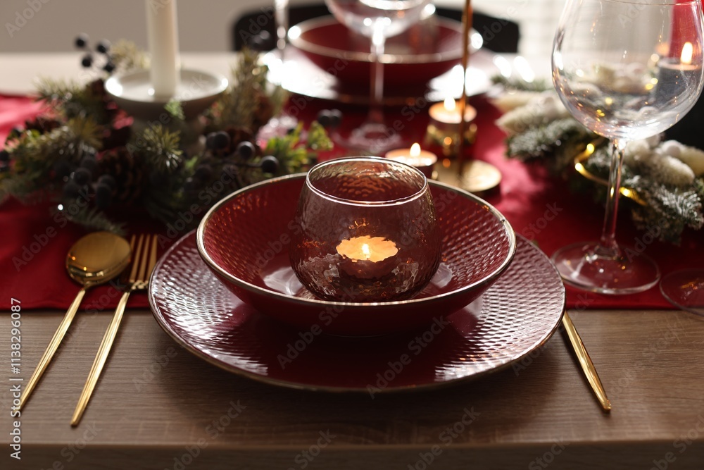 Christmas place setting with festive decor on wooden table in room, closeup Christmas place setting with festive decor on wooden table in room, closeup