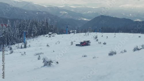 Snowmobile machine at winter resort in snowy mountains