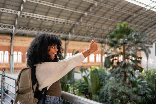 Young black woman taking selfie at atocha station in madrid photo