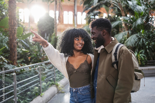 Tourists pointing and smiling in atocha train station, madrid