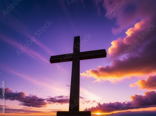 Sunset behind wooden cross silhouetted against vibrant sky with clouds photo