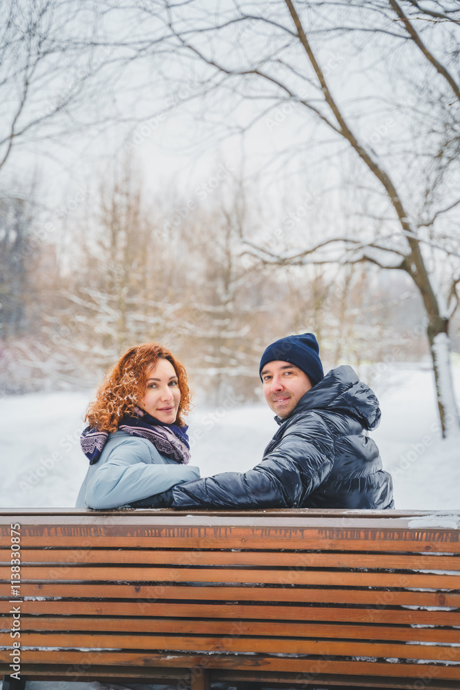 Love romantic love story. Happy couple of middle aged millennials, bright red-haired woman in winter snow park. Romantic date, kissing, hugging. Walking, having fun. Stylish blue clothes, jacket, hat Love romantic love story. Happy couple of middle aged millennials, bright red-haired woman in winter snow park. Romantic date, kissing, hugging. Walking, having fun. Stylish blue clothes, jacket, hat