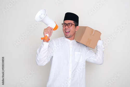 Muslim man announce something using megaphone with excited expression while carrying a cardboard box photo