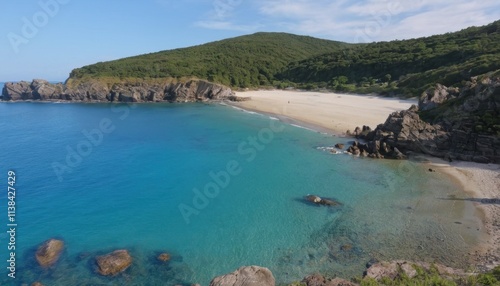 Panoramic view of the beach and sea with clear blue water, sandy shore, and distant mountains under a sunny sky, capturing a peaceful coastal landscape in Greece during summer