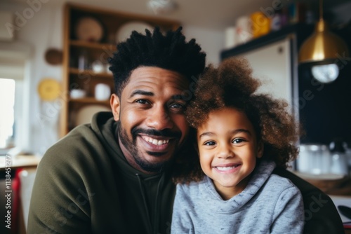 Smiling portrait of a young father and his daughter at modern home