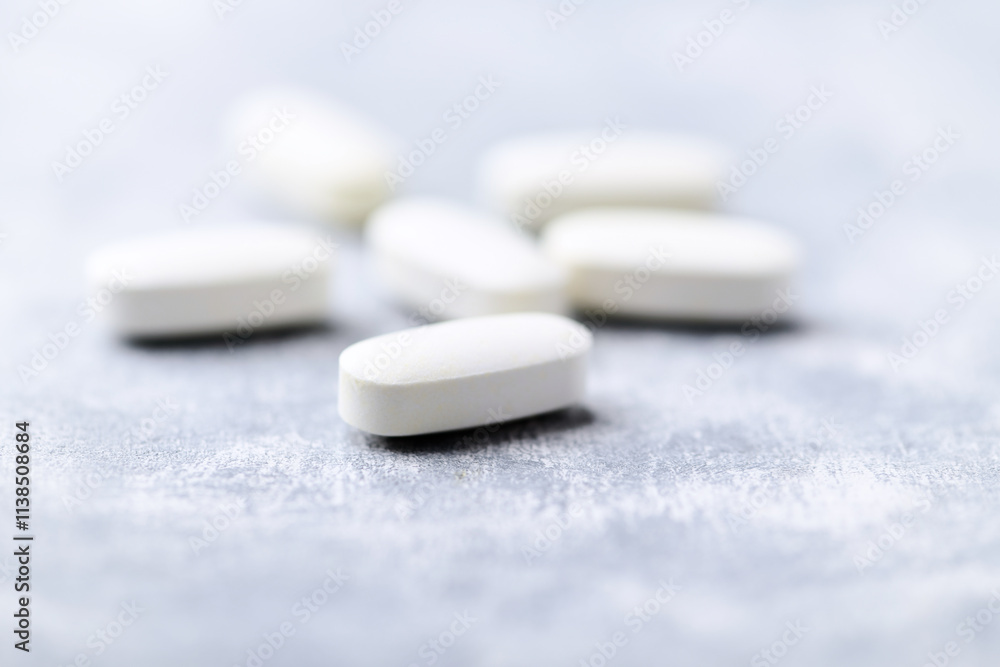 Arginine alpha-ketoglutarate (AAKG) tablets. Bodybuilding food supplements on wooden background. Soft focus. Close up. Copy space. Arginine alpha-ketoglutarate (AAKG) tablets. Bodybuilding food supplements on wooden background. Soft focus. Close up. Copy space.