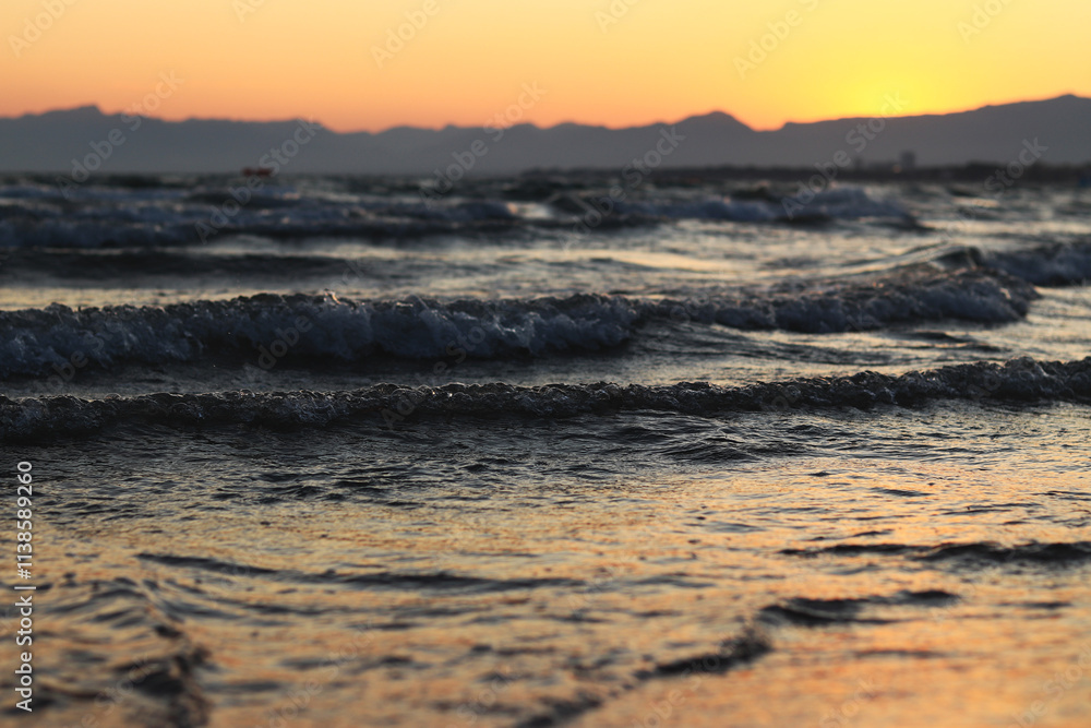 Sunset at sea. Beautiful sunset landscape on the Balearic Sea. View of the sea with small waves. View of the waves on the sea from a lower angle. Salou, Spain Sunset at sea. Beautiful sunset landscape on the Balearic Sea. View of the sea with small waves. View of the waves on the sea from a lower angle. Salou, Spain