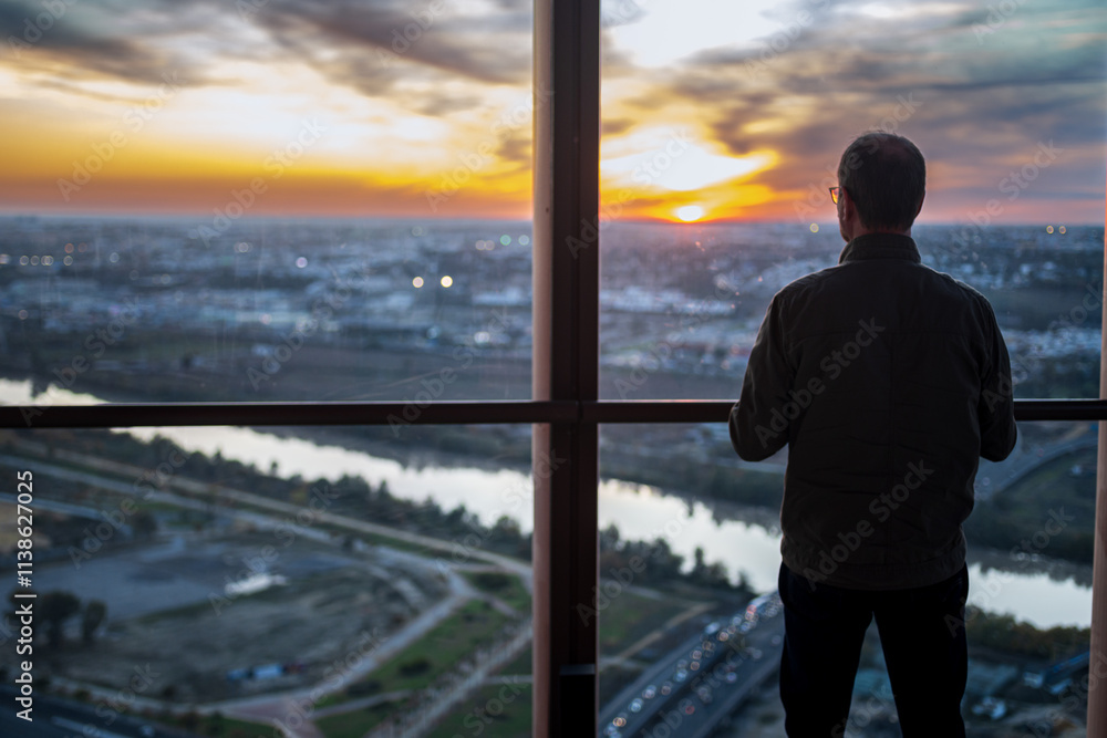 Fototapeta premium Person enjoys sunset view from Torre Sevilla observation deck in Seville
