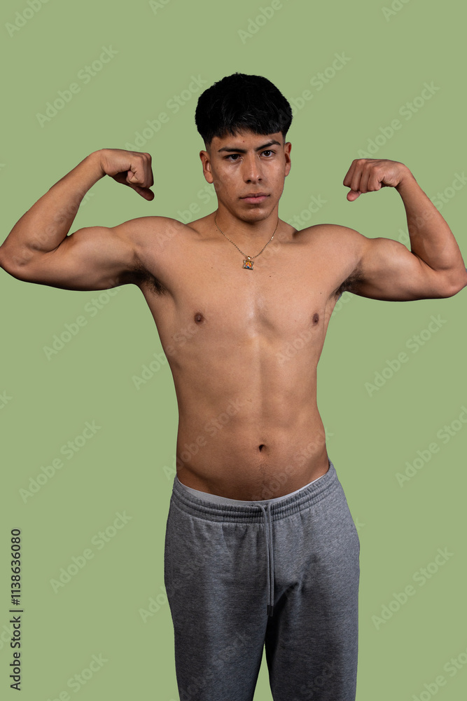 Young latino man showing muscles on green background Young latino man showing muscles on green background