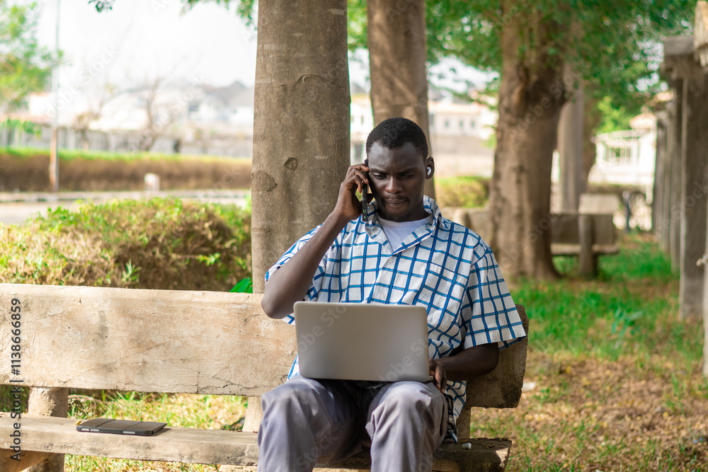 Young cheerful black man using mobile phone and laptop computer. Modern lifestyle Young cheerful black man using mobile phone and laptop computer. Modern lifestyle