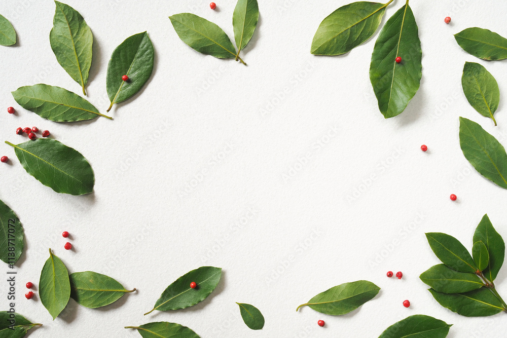 Fototapeta premium Fresh green bay leaves and pink Peruvian pepper peas on a white background. Top view. Copy space