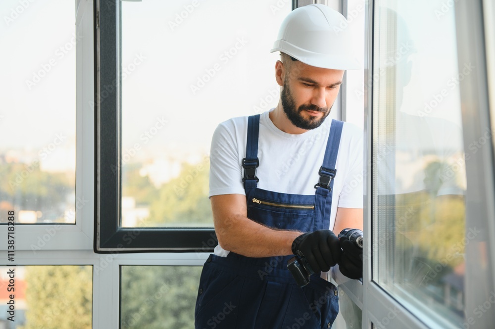 Worker installing plastic window indoors Worker installing plastic window indoors