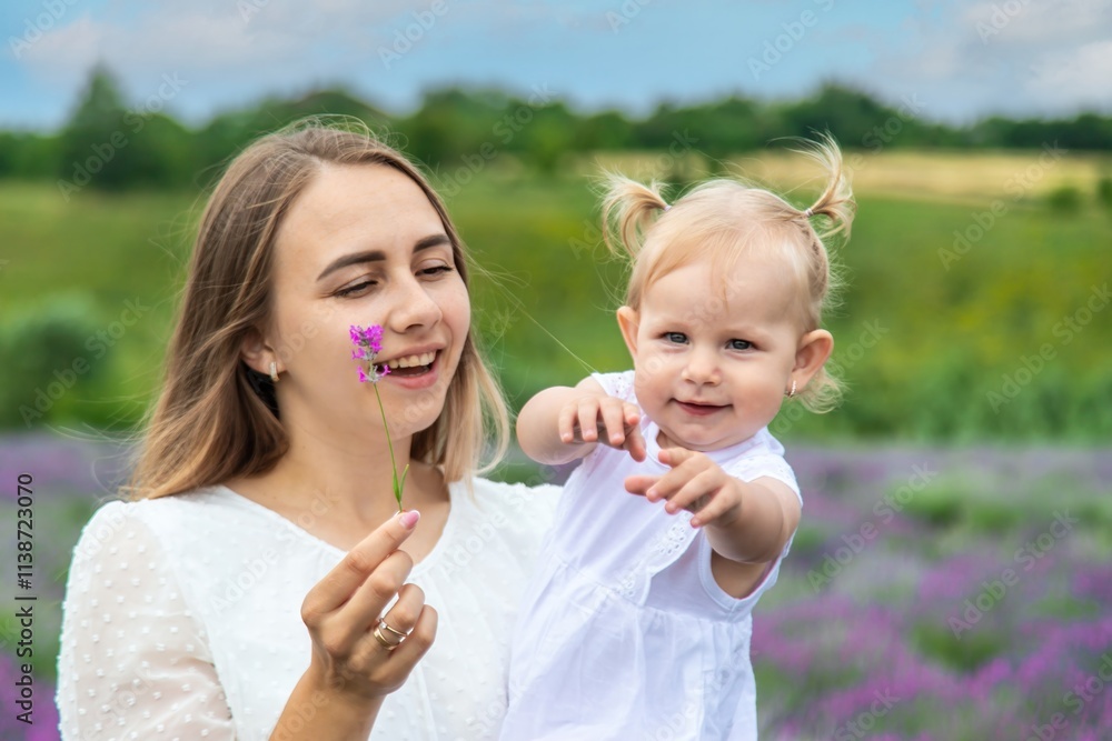 Fototapeta premium Happy mother and daughter in a lavender field