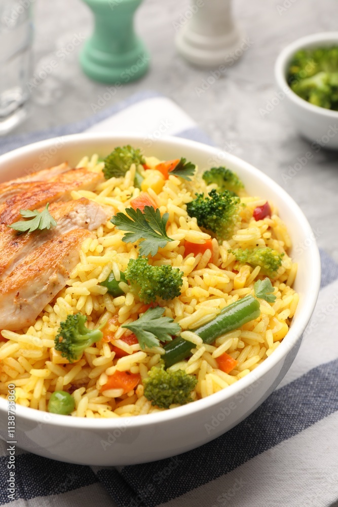 Tasty rice with vegetables and chicken on table, closeup Tasty rice with vegetables and chicken on table, closeup