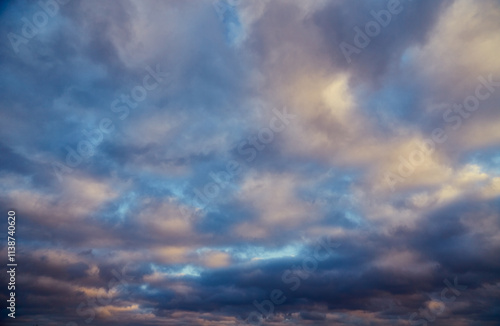 Sunlight pierces gray-white clouds in the cold winter sky. photo