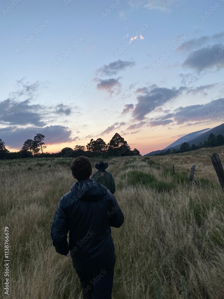 Sunset hike through scenic grassy field Sunset hike through scenic grassy field