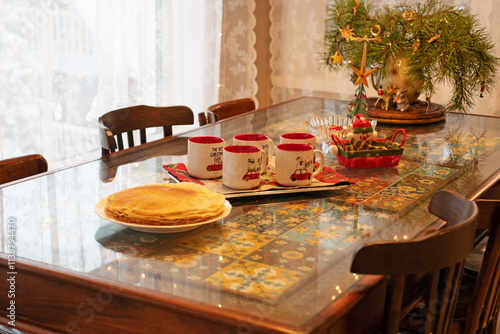 Obraz na płótnie Christmas cozy background with big family table and mugs at beautiful veranda w salonie
