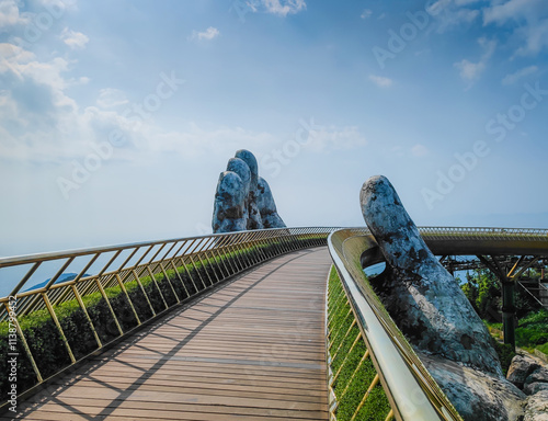 Golden Bridge in Ba Na hills, Da Nang, Vietnam on a sunny day. Lifted by two giant concrete hands. Iconic world famous bridge in the mountains