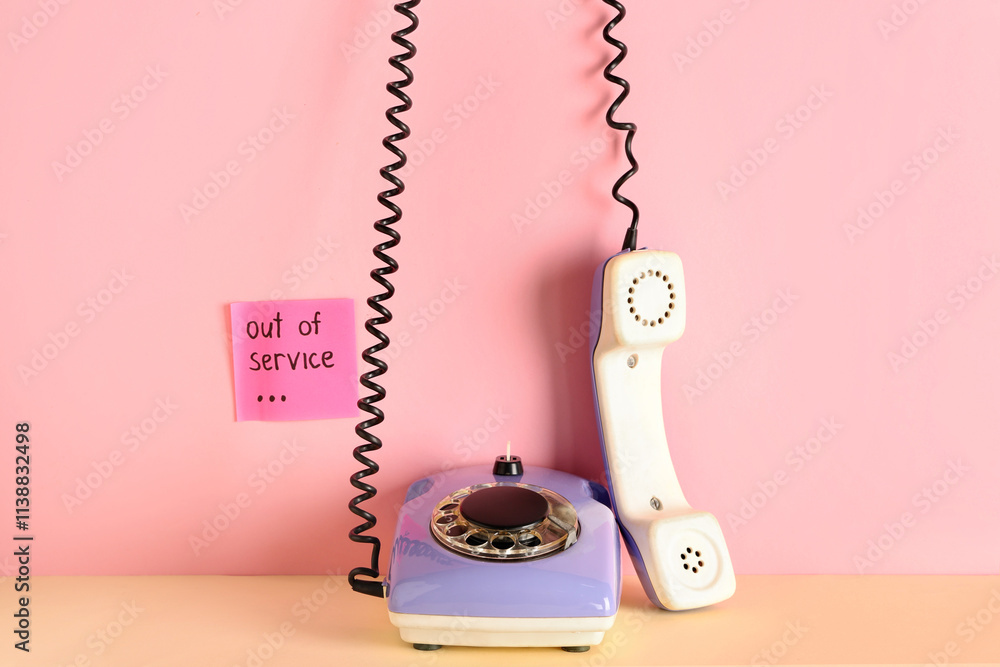 Lilac retro telephone and sticker with text OUT OF SERVICE on pink background Lilac retro telephone and sticker with text OUT OF SERVICE on pink background