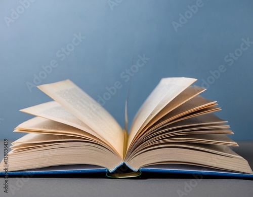 An open textbook with pages mid-turn, placed on a table. The hardcover book represents concepts