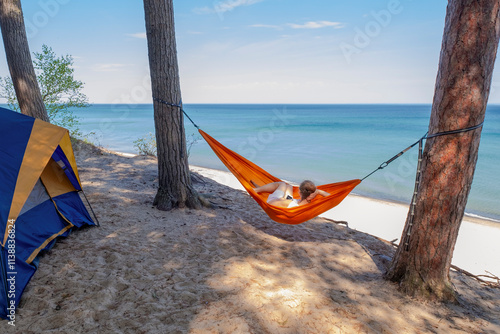 Obraz na płótnie Woman in hammock observes Lake Superior from her camping site on a cliff w salonie